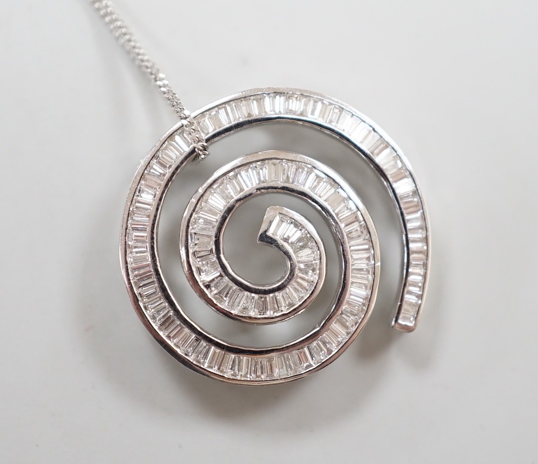 A modern 750 white metal and baguette cut diamond set whorl design pendant, 22mm, gross 4.5 grams, on a 9ct white gold fine link chain, 46cm, 1.1 grams.
